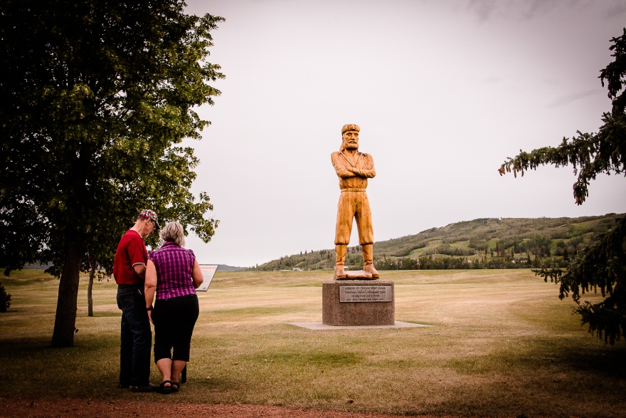 A couple reads the information plaque next to the Twelve Foot Davis Statue